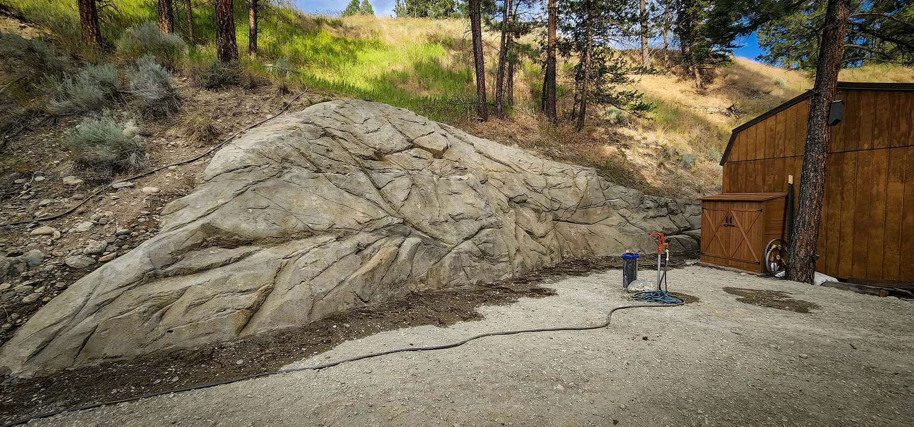 Hillside retaining wall carved as natural ledge rock