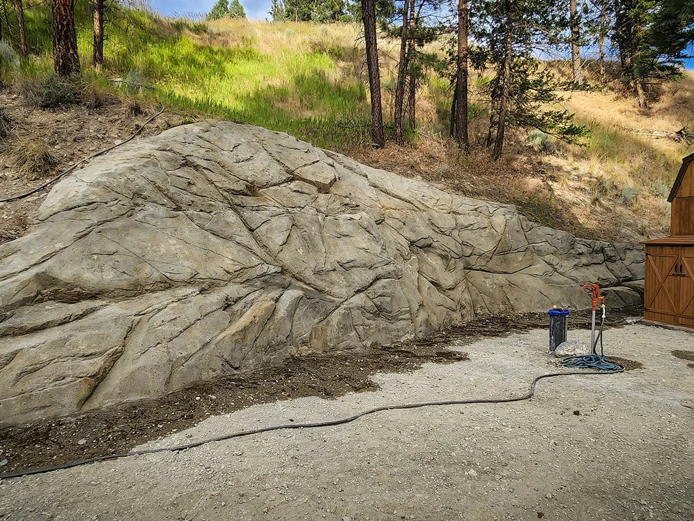 Finished carved and colored concrete retaining wall on a hillside